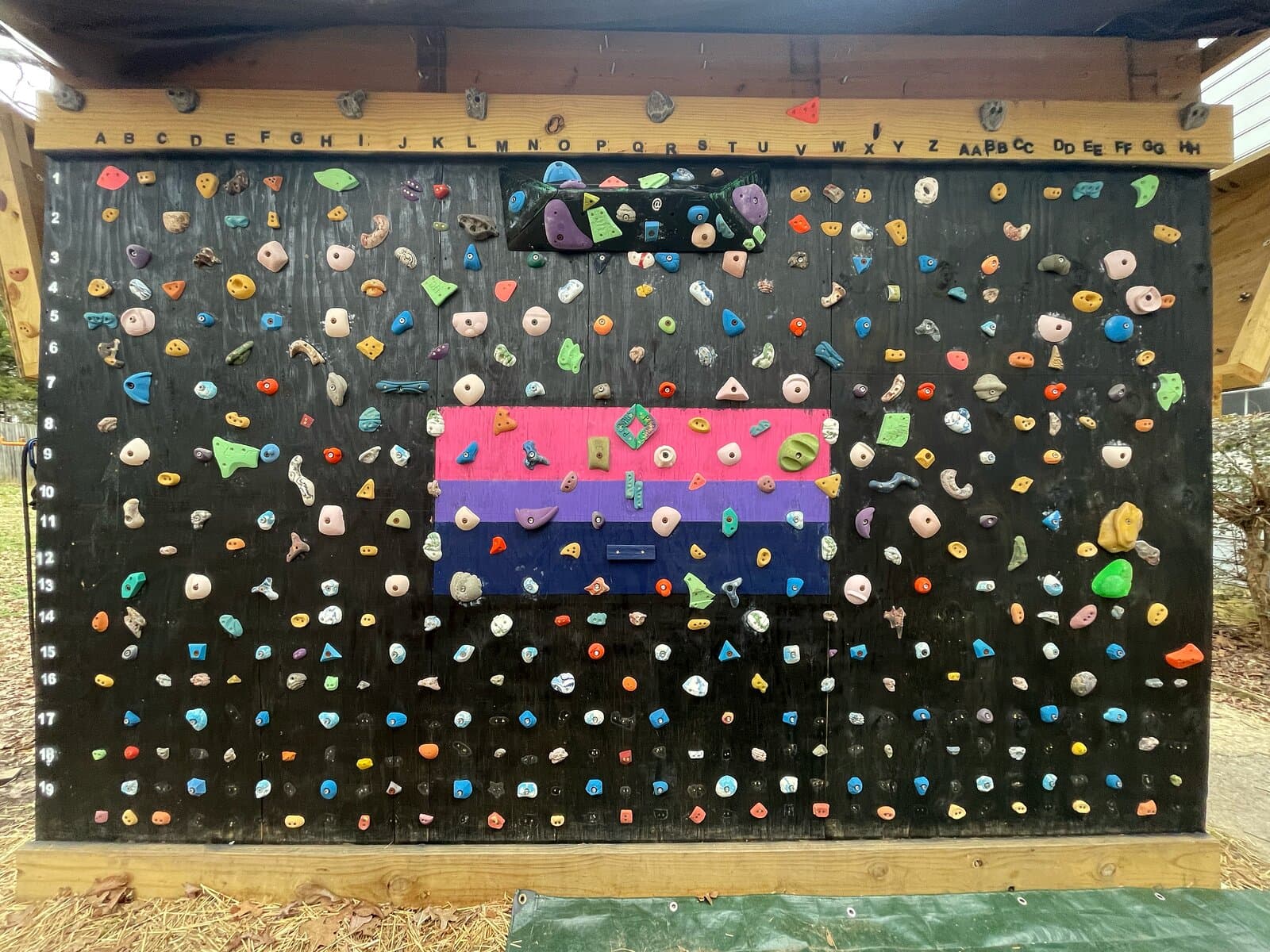 A black slab climbing wall set with holds