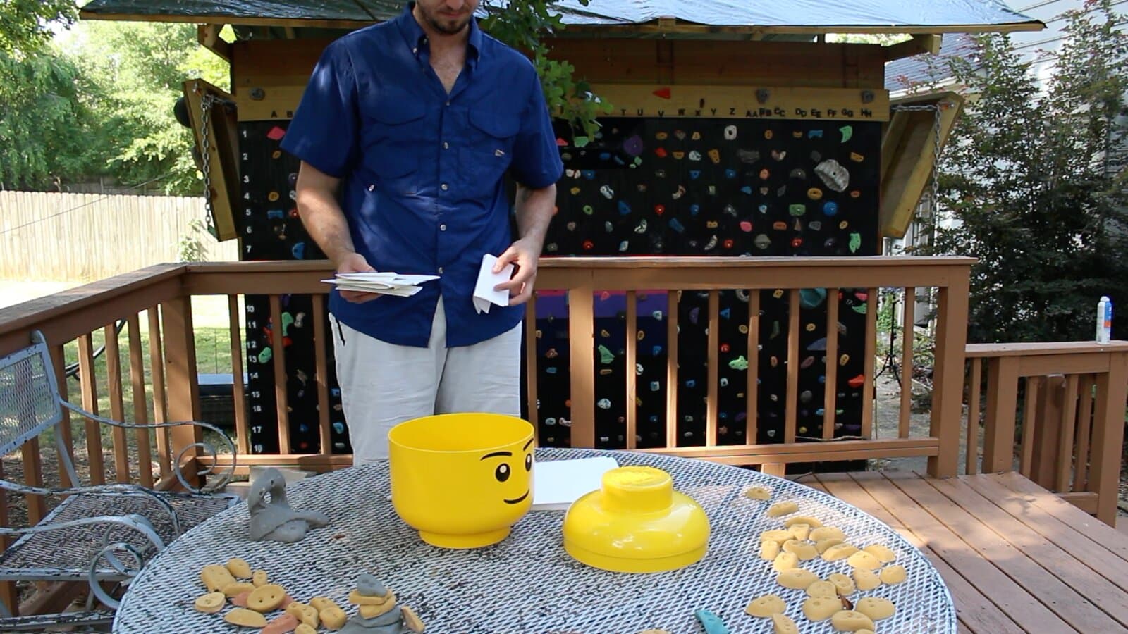 A person reading votes beside an opened yellow LEGO-head jar used as the voting urn
