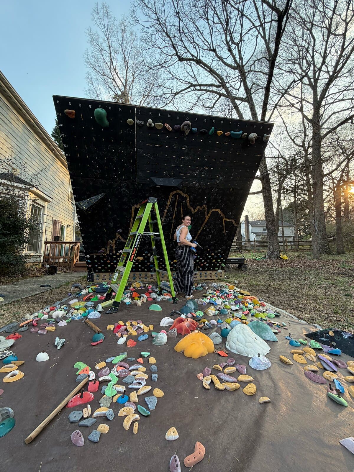 The main wall stripped of holds, with hundreds of holds spread out on a tarp in front of it